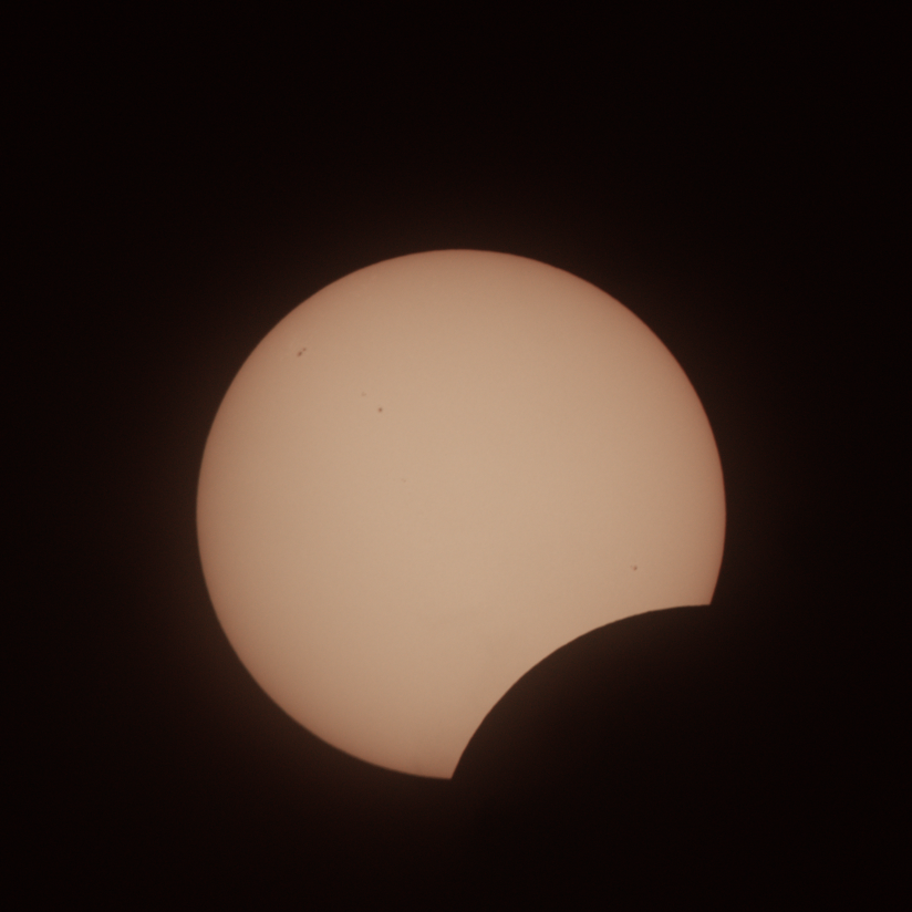 The sun with a bit less than a quarter in the bottom right blocked by the moon