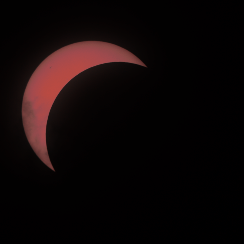 The sun with a bit more than three quarters blocked by the moon, leaving a crescent in the top left