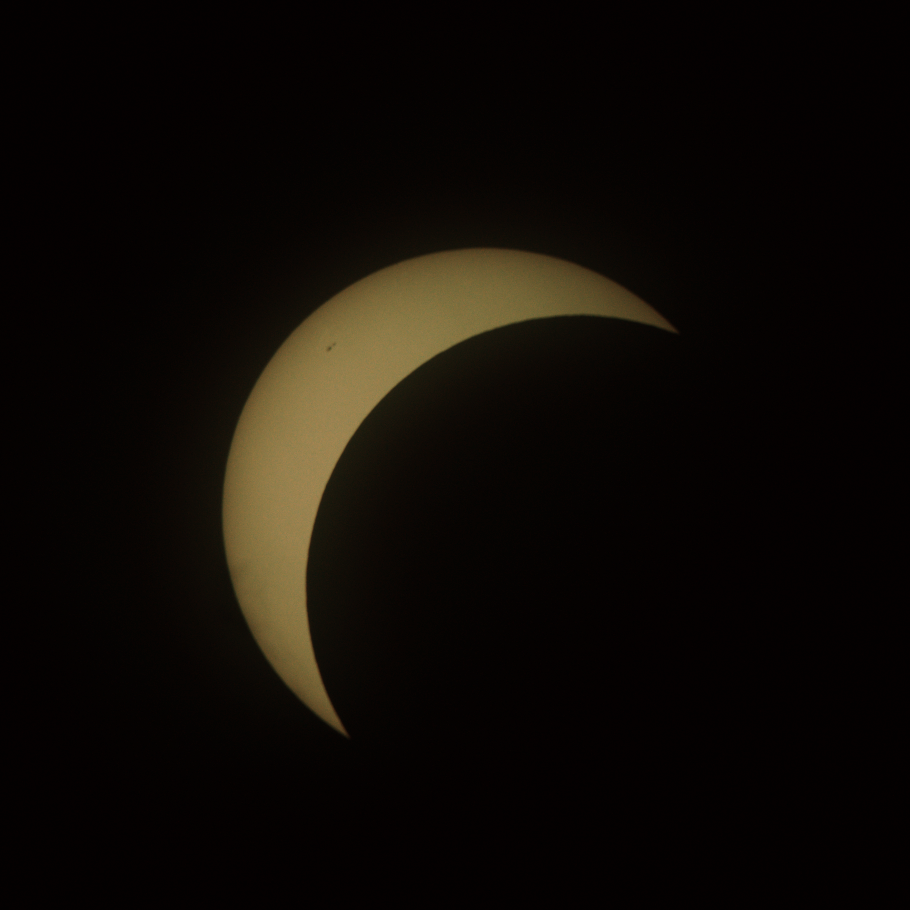 The sun with a bit more than three quarters blocked by the moon, leaving a crescent in the top left
