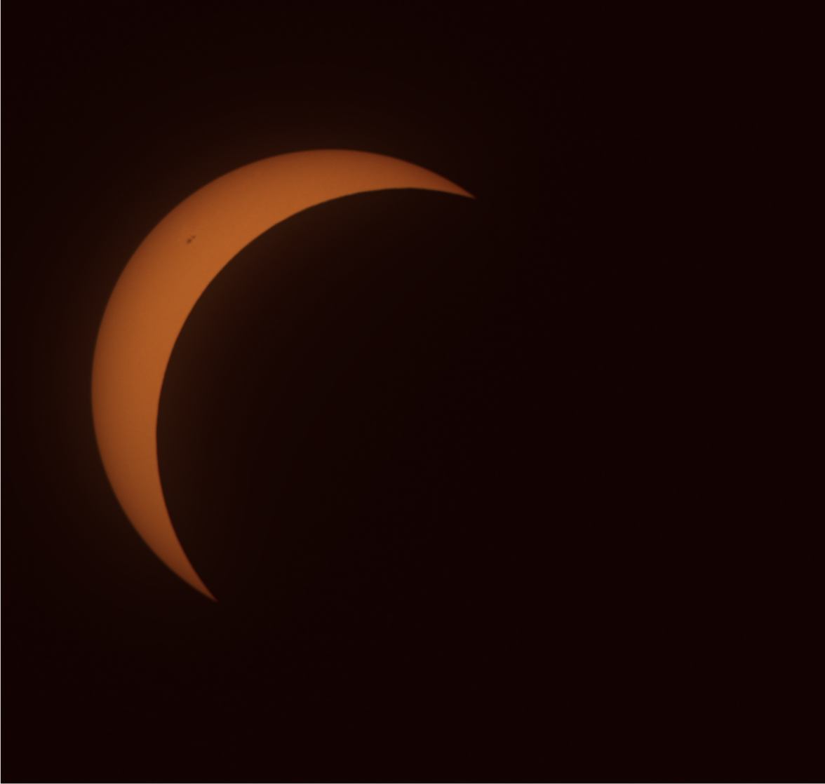 The sun, reduced by the moon to a thin crescent in the top left